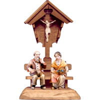 Starí rodičia sediaci pod poľným krížom