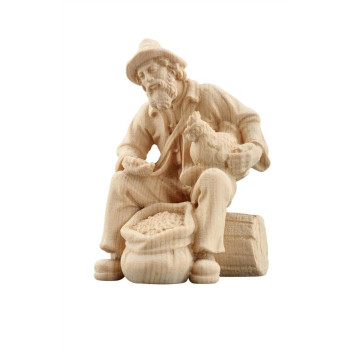 Shepherd sitting with fodder and hen for Nativity scene - Alpine